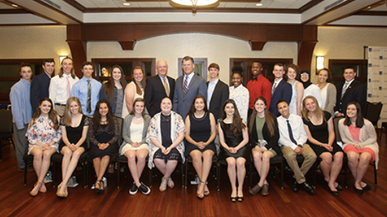 A group of scholarship recipients and '.BNAME.' employees posing for the camera at an event